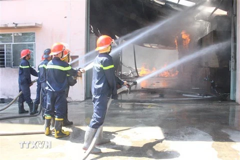 Lực lượng chữa cháy tích cực khống chế ngọn lửa. (Ảnh: Nguyễn Văn Việt/TTXVN)