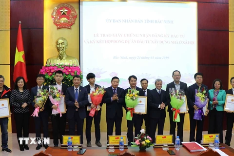 Các lãnh đạo tỉnh Bắc Ninh trao giấy chứng nhận cho các nhà đầu tư. (Ảnh: Trương Diệp/TTXVN)