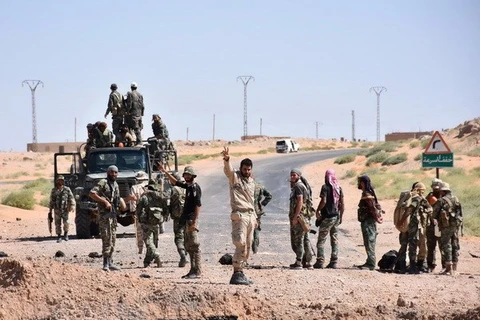 Lực lượng Chính phủ Syria tuần tra trên tuyến đường nối Kabajeb với Al-Shula, ngoại ô Deir Ezzor. (Ảnh: AFP/TTXVN)