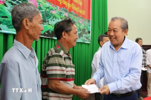 Phó Thủ tướng Trương Hòa Bình tặng quà cho các gia đình hộ nghèo hai huyện Tháp Mười và Cao Lãnh, tỉnh Đồng Tháp. (Ảnh: Chương Đài/TTXVN)