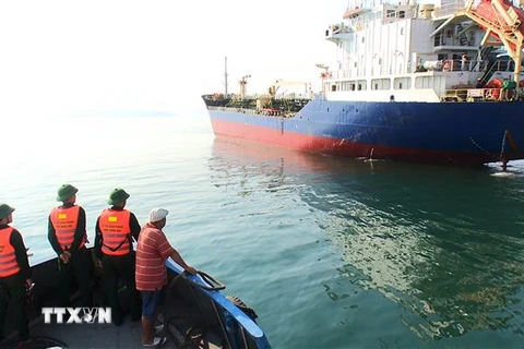 Tàu của Đồn Biên phòng cửa khẩu cảng Chân Mây tiếp cận tàu chở thuyền viên bị nạn. (Ảnh Hồ Cầu/TTXVN)