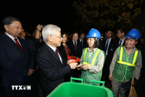 Tổng Bí thư, Chủ tịch nước Nguyễn Phú Trọng thăm hỏi, tặng quà và chúc Tết công nhân môi trường đang làm việc trong đêm Giao thừa tại Hà Nội. (Ảnh: Trí Dũng/TTXVN)