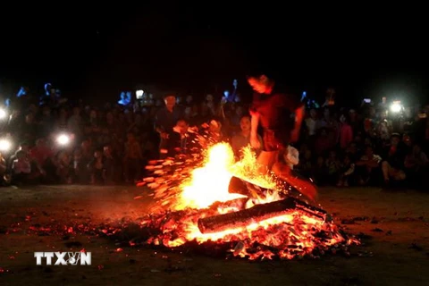 Như được truyền sức mạnh siêu nhiên nào đó, những thanh niên người Dao Đỏ nhảy vào giữa đống lửa đang cháy rừng rực bằng đôi chân trần trong sự ngỡ ngàng của người xem. (Ảnh: Văn Tý/TTXVN)