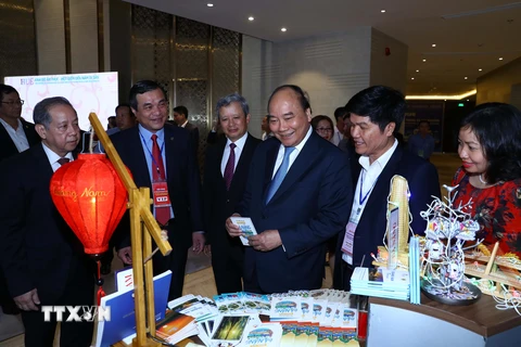 Thủ tướng Nguyễn Xuân Phúc và các đại biểu thăm các gian hàng trưng bày tại hội nghị. 