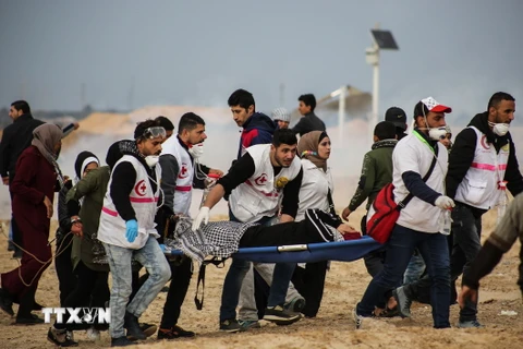  Nhân viên y tế chuyển người Palestine bị thương trong cuộc đụng độ với binh sĩ Israel tại khu vực biên giới Dải Gaza-Israel, ngày 19/2/2019. (Ảnh: THX/TTXVN)