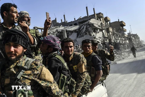Các thành viên Lực lượng Dân chủ Syria sau chiến dịch truy quét các tay súng Tổ chức Nhà nước Hồi giáo (IS) tự xưng tại thành phố Raqa, miền Bắc Syria ngày 20/10/2017. (Ảnh: AFP/TTXVN)