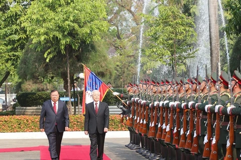 Tổng Bí thư, Chủ tịch nước Lào Bounnhang Vorachith và Tổng Bí thư, Chủ tịch nước Nguyễn Phú Trọng duyệt đội danh dự Quân đội nhân dân Lào tại Lễ đón chính thức. (Ảnh: Trí Dũng/TTXVN)