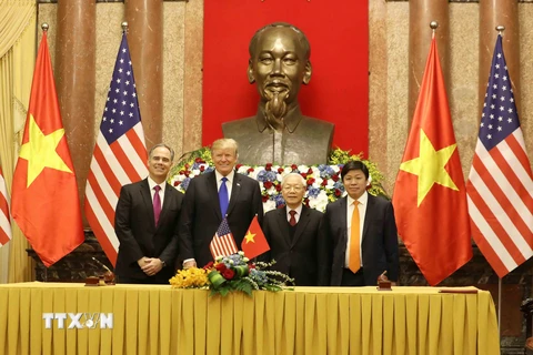 Tổng Bí thư, Chủ tịch nước Nguyễn Phú Trọng và Tổng thống Hoa Kỳ Donald Trump với các đại biểu tham gia ký kết thỏa thuận thương mại giữa VietjetAir và Công ty General Electric. (Ảnh: Phương Hoa/TTXVN)