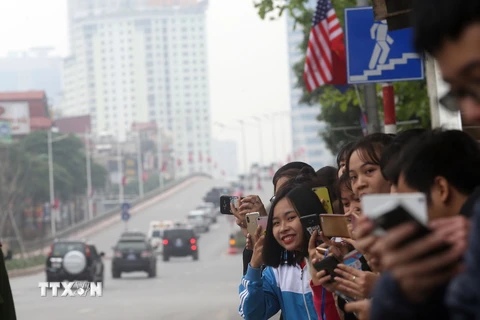 Người dân đứng trên phố Trần Duy Hưng đón đoàn xe của Tổng thống Mỹ Donald Trump đi qua. (Ảnh: Huy Hùng/TTXVN)