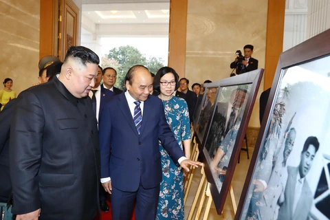 Thủ tướng Nguyễn Xuân Phúc giới thiệu với Chủ tịch Triều Tiên Kim Jong-un những bức ảnh tiêu biểu về quan hệ giữa hai nước trong 69 năm qua do các phóng viên ảnh của TTXVN chụp. (Ảnh: Thống Nhất/TTXVN)