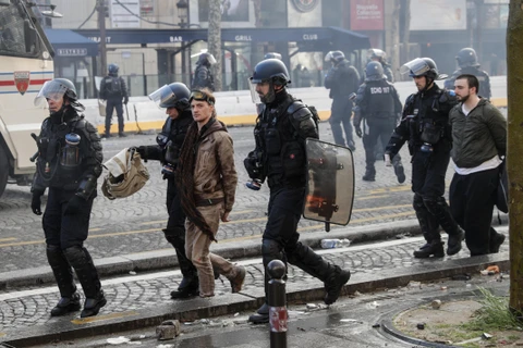 Cảnh sát chống bạo động bắt giữ những người biểu tình Áo vàng quá khích tại Paris ngày 16/3. (Ảnh: AFP/TTXVN)
