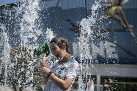 Người dân tránh nóng tại vòi phun nước ở Melbourne, Australia, ngày 24/1/2019. (Ảnh: THX/TTXVN)