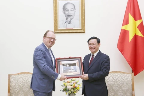 Phó Thủ tướng Vương Đình Huệ tặng quà lưu niệm cho ông Andrea Schaal. (Ảnh: Dương Giang/TTXVN)