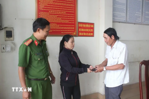 Chị Lê Thị Hậu trao trả lại tài sản cho người đánh rơi tại Công an phường Thanh Bình, thành phố Biên Hòa. (Ảnh: Sỹ Tuyên/TTXVN)