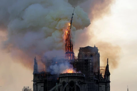 Ngọn tháp của Nhà thờ Đức Bà Paris đổ sập trong vụ hỏa hoạn ngày 15/4/2019. (Ảnh: AFP/ TTXVN)
