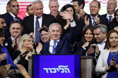 Thủ tướng Israel Benjamin Netanyahu (giữa) vẫy chào những người ủng hộ sau khi kết quả bầu cử được công bố, tại trụ sở đảng Likud ở Tel Aviv, ngày 10/4. (Ảnh: AFP/TTXVN)