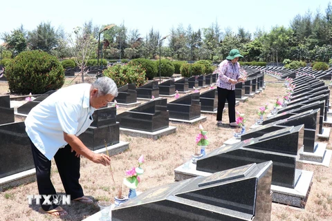 Ông Huỳnh Đồng (nguyên Trung đội trưởng Trinh sát-Đoàn 10) và bà Phạm Thị Nhung (cán bộ y tá Đoàn 10) thắp nhang cho các đồng đội tại Nghĩa trang Liệt sỹ Rừng Sác. (Ảnh: Xuân Khu/TTXVN)