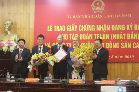 Lãnh đạo tỉnh Hà Nam tặng hoa chúc mừng 2 chủ đầu tư dự án. (Ảnh: Nguyễn Chinh/TTXVN)