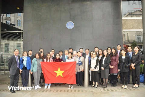 Cán bộ, nhân viên Đại sứ quán, các cơ quan đại diện Việt Nam, học sinh, sinh viên cùng đại diện bà con Việt kiều tại Anh chụp ảnh kỷ niệm dưới Biển tưởng niệm Bác Hồ tại Tòa nhà New Zealand. (Ảnh: Đình Thư/Vietnam+)