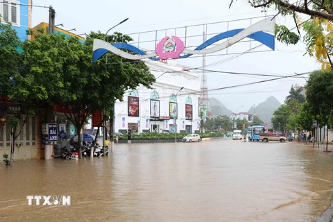 Đường Trường Chinh, thành phố Sơn La bị ngập úng, gây ách tắc giao thông và nước tràn vào nhà dân, cửa hàng bên đường. (Ảnh: Nguyễn Cường/TTXVN)