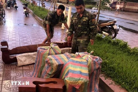 Cán bộ, chiến sỹ Đồn Biên phòng cửa khẩu quốc tế Tịnh Biên đang kiểm đếm tang vật thu giữ. (Ảnh: Công Mạo/TTXVN)