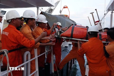 Lực lượng cứu hộ đưa nạn nhân từ tàu SAR 274 lên bờ để chuyển tiếp vào bệnh viện tại Đà Nẵng điều trị. (Ảnh: TTXVN)