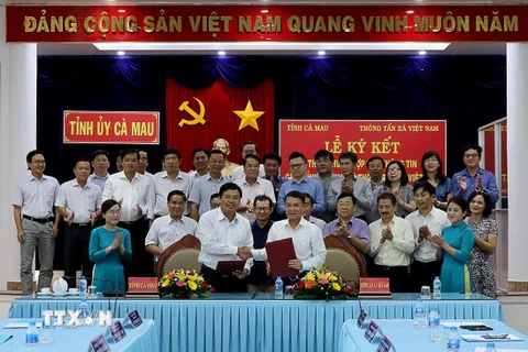 Tổng Giám đốc TTXVN Nguyễn Đức Lợi và Chủ tịch Ủy ban Nhân dân tỉnh Cà Mau Nguyễn Tiến Hải ký kết thỏa thuận hợp tác truyền thông. (Ảnh: Kim Há/TTXVN)