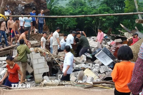 Người dân đào bới đống đổ nát của căn nhà bị sập, cứu 3 thành viên trong gia đình anh Nông Văn Trường. (Ảnh: CTV/TTXVN)