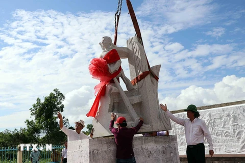 Thực hiện nghi thức đặt tượng đài kỷ niệm ngành giao bưu và vô tuyến điện Nam Bộ tại buổi lễ. (Ảnh: Kim Há/TTXVN)