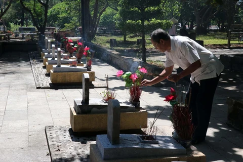 Người dân dâng hương lên các phần mộ tại Nghĩa trang Liệt sỹ Quốc gia Trường Sơn. (Ảnh: Nguyên Lý/TTXVN)