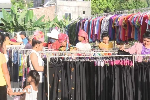Người dân lựa chọn đồ may mặc hàng Việt Nam. (Ảnh minh họa: Nguyễn Cường/TTXVN)