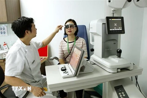 Các bác sỹ Bệnh viện Mắt Hà Nội 2 khám, tư vấn cho người bệnh. (Ảnh: Dương Ngọc/TTXVN)
