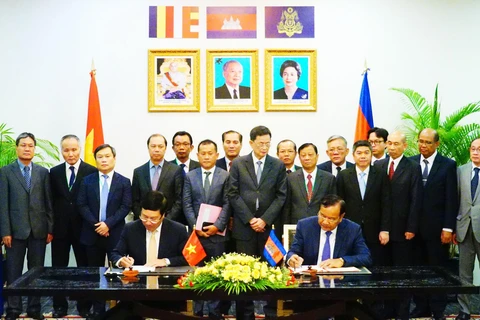 Phó Thủ tướng, Bộ trưởng Ngoại giao Phạm Bình Minh và Phó Thủ tướng, Bộ trưởng Bộ Ngoại giao và Hợp tác quốc tế Campuchia Prak Sokhonn ký kết văn kiện của Kỳ họp. (Ảnh: Minh Hưng/TTXVN)