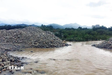Nhiều đống đá lớn đã được doanh nghiệp khai thác, tập kết đã cản trở dòng chảy của sông Dinh. (Ảnh: Công Thử/TTXVN)
