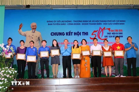Lãnh đạo Liên đoàn Lao động Thành phố Hồ Chí Minh trao giấy khen cho các thí sinh đạt thành tích cao ở nội dung viết. (Ảnh: Thanh Vũ/TTXVN)