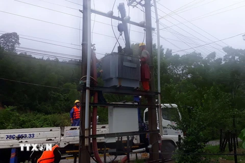 Công nhân ngành điện Quảng Bình kiểm tra, sửa chữa điện lưới trong mùa mưa lũ. (Ảnh: Đức Thọ/TTXVN)
