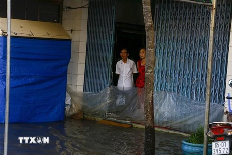 Nước ngập sâu trên đường Mậu Thân, quận Ninh Kiều khiến việc sinh hoạt, mua bán của người dân bị ảnh hưởng. (Ảnh: Thanh Liêm/TTXVN)