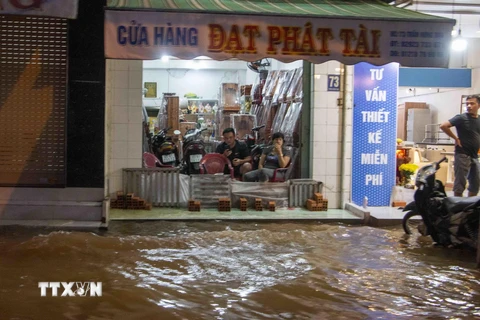 Nước ngập sâu ở Cần Thơ khiến việc kinh doanh của người dân bị gián đoạn. (Ảnh: Thanh Liêm/TTXVN)