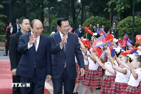 Thủ tướng Chính phủ Nguyễn Xuân Phúc đón và Thủ tướng Vương quốc Campuchia Samdech Techo Hun Sen với thiếu nhi Thủ đô Hà Nội tại Lễ đón. (Ảnh: Thống Nhất/TTXVN)