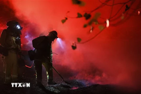 Lính cứu hỏa nỗ lực dập lửa tại một điểm cháy rừng ở Santa Clarita, bang California (Mỹ) ngày 24/10/2019. (Ảnh: THX/TTXVN)