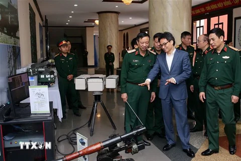 Phó Thủ tướng Vũ Đức Đam tham quan trưng bày mô hình vũ khí trang bị. (Ảnh: Dương Giang/TTXVN)