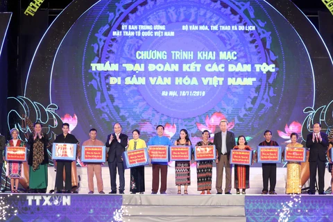 Thủ tướng Nguyễn Xuân Phúc cùng các lãnh đạo Đảng, Nhà nước trao quà cho đồng bào các dân tộc sống và sinh hoạt tại Làng. (Ảnh: Thống Nhất/TTXVN)