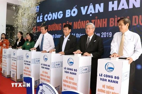 Đại biểu thực hiện nghi thức bấm nút chính thức đưa vào hoạt động Hệ thống đường dây nóng tỉnh Bình Dương 1022. (Ảnh: Nguyễn Văn Việt/TTXVN)