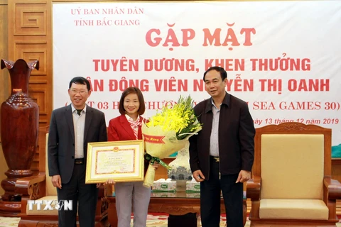 Lãnh đạo tỉnh Bắc Giang trao tặng bằng khen cho vận động viên Nguyễn Thị Oanh. (Ảnh: Đồng Thúy/TTXVN)
