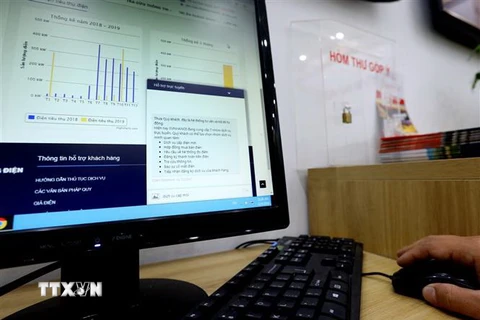 Khách hàng có thể thực hiện những giao dịch về dịch vụ điện qua các thiết bị điện tử (ảnh chụp tại Phòng giao dịch khách hàng Công ty Điện lực Hoàn Kiếm, Hà Nội). (Ảnh: Ngọc Hà/TTXVN)
