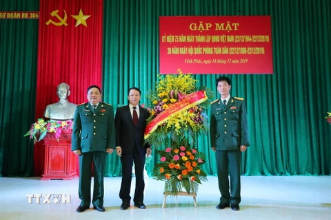 Tổng Giám đốc TTXVN Nguyễn Đức Lợi tặng hoa chúc mừng Sư đoàn 304. (Ảnh: Thành Đạt/TTXVN)