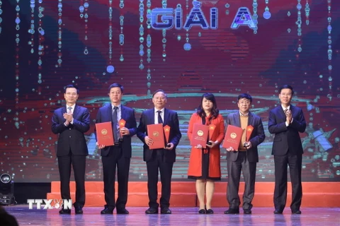 Trưởng ban Tuyên giáo Trung ương Võ Văn Thưởng và Bộ trưởng Bộ Thông tin và Truyền thông Nguyễn Mạnh Hùng trao giải A cho các tác giả đoạt giải. (Ảnh: Minh Quyết/TTXVN)