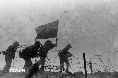 Các chiến sỹ giải phóng phất cờ chiến thắng trên nóc lô cốt địch ở điểm cao 365 (Quảng Trị), ngày 30/3/1972. (Ảnh: Tư liệu TTXVN)