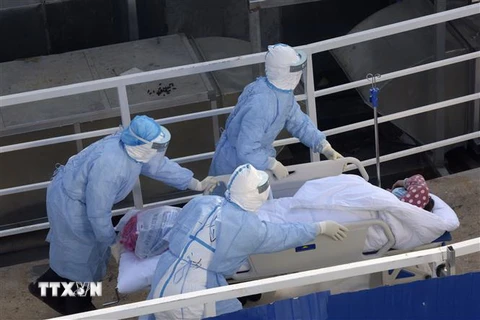 Nhân viên y tế chuyển bệnh nhân nhiễm virus corona chủng mới tới điều trị tại bệnh viện dã chiến Hỏa Thần Sơn ở Vũ Hán, tỉnh Hồ Bắc, Trung Quốc, ngày 4/2/2020. (Ảnh: THX/TTXVN)