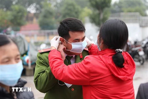 Cán bộ, hội viên Hội Chữ thập đỏ thành phố Hà Nội tuyên truyền, phát khẩu trang miễn phí tại Gia Lâm. (Ảnh: Thanh Tùng/TTXVN)